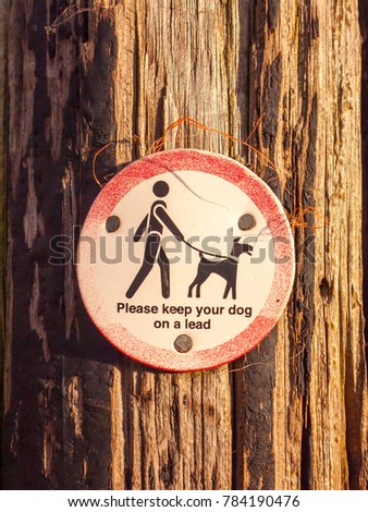 public walking wooden sign post dog sign please keep your dog on a lead; essex; england; uk