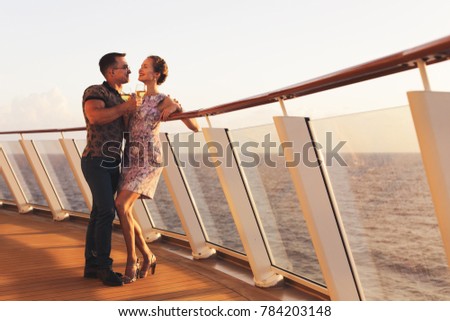 handsome man and beautiful woman standing with glasses white wine on cruise ship in Caribbean sea at nice sunset  background