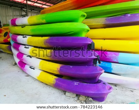 Canoe made of colorful plastic were piled together in the boathouse. Royalty-Free Stock Photo #784223146