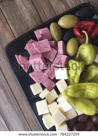 Ham, cheese, olive, salami in black tray for appetizer