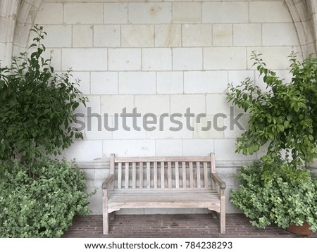 A white wooden bench between tree