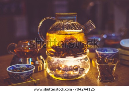 Blooming Flower Tea in Glass Tea Pot with traditional chinese accessories. Toned
