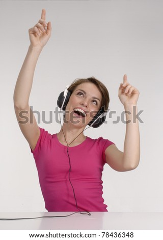 Young woman listening music using headphones.