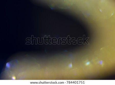 Bokeh golden curve shape, abstract blurry background with black background.