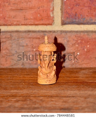 Wooden elephant statuette, hand carved, brick wall background