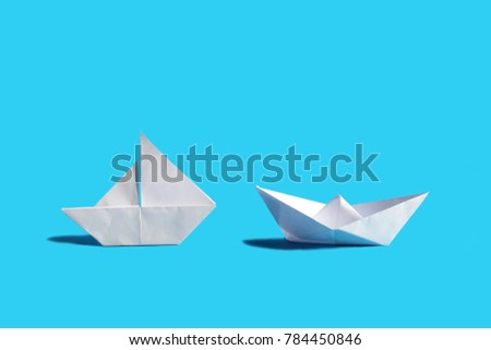 Two paper boat on blue background
