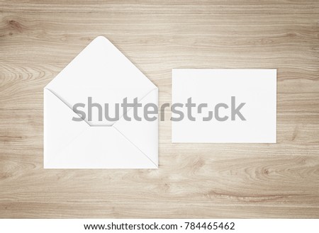 White opened envelope mockup isolated on a wooden background. 