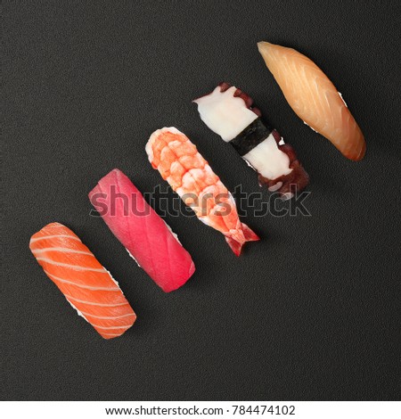 Japanese cuisine. Sushi with fresh ingredients over black background.