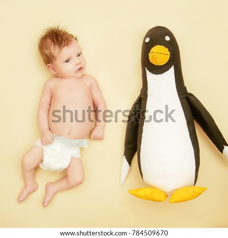 

Portrait of adorable newborn baby with her penguin friend
