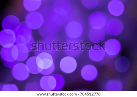 Photo of purple bokeh lights on black background in the City night. Effect golden light texture and design. Soft focus.