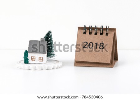 Little house model and tree on white background with calendar 2018