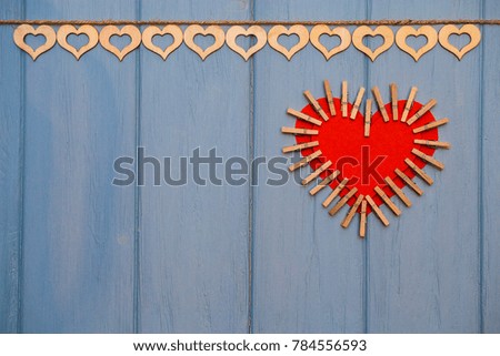 Red paper Heart of love with clips on blue wooden background. Romantic symbol. Love concept