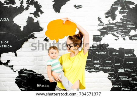 Man holding a colorful bubble above the head sitting at the office with world map on the background dreaming about traveling