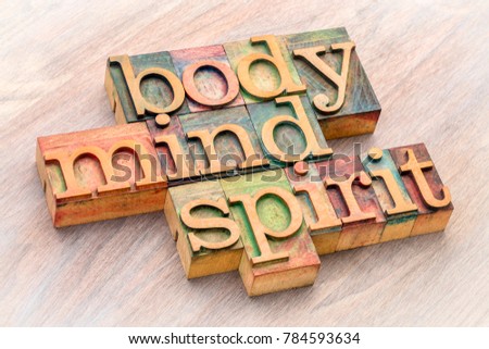 body, mind and spirit word abstract in letterpress wood type against grained wood