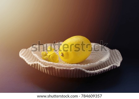 Lemon on White Ceramic Plate with Yellow Flower     Deep Blue with Warm Glare Copy Space