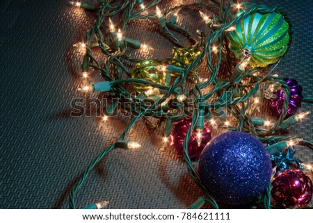 black rubber background with christmas decorations scattered on it