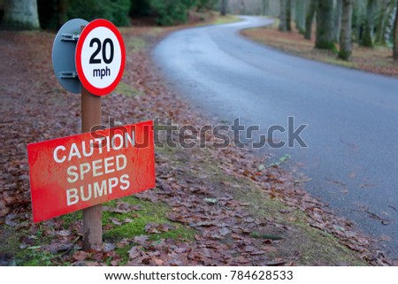 Speed bumps caution 20 mph sign road safety in rural countryside estate