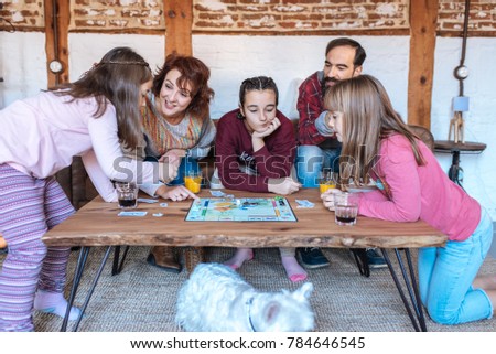 Happy family at home in the couch playing classic table games 
