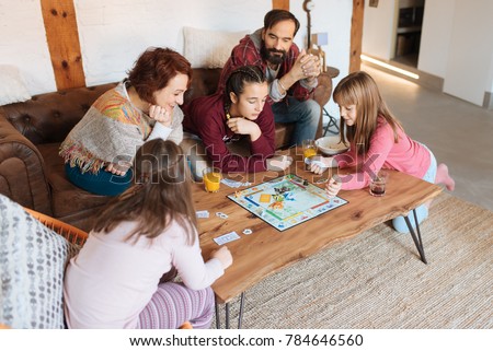 Happy family at home in the couch playing classic table games 
 Royalty-Free Stock Photo #784646560