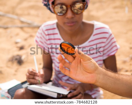 Color filters for photos. Girl looks through orange glass