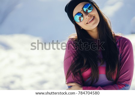 young and stylish brunette in the snowy mountains