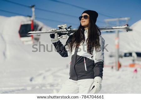 young and active brunette skiing in the snowy mountains