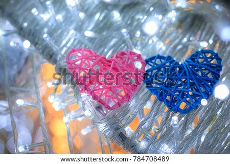 Abstract blurred bokeh and heart background for valentine love concept.Soft focus couple heart sharp hand made with bamboo two color pink and blue in circle bokeh led background with copy space.