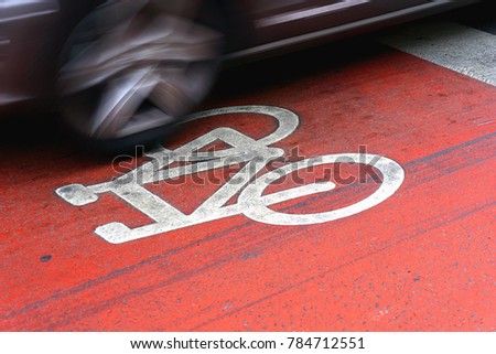 Danger road situation in the city when car driving through the bicycle way marked with white oaint bicycle sign on street red asphalt