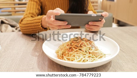 Woman taking photo on dishes in restaurant 