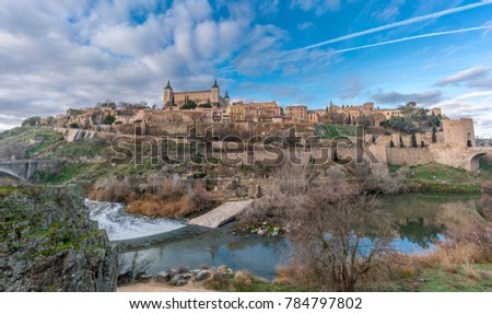 Toledo cityscape, Alcazar and Alcantara gate over the tagus (Tajo) river. UNESCO world heritage site.