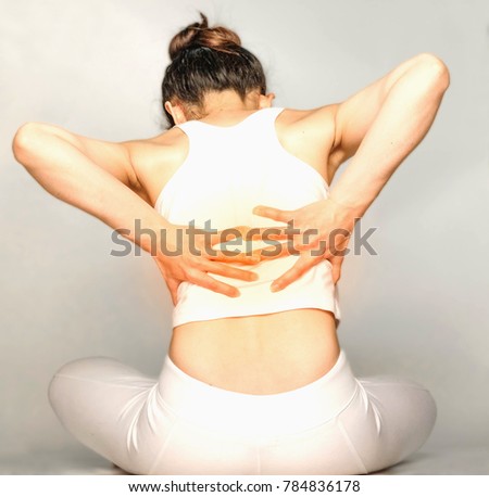 young woman in white clothes , grabbing an back, She has back pain. Waist pain And Care Concept.