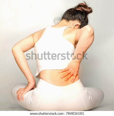 young woman in white clothes , grabbing an Waist, She has back pain. Waist pain And Care Concept.