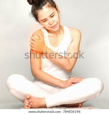 young woman in white clothes , grabbing an arm, She has Upper arm pain. Waist pain And Care Concept.
