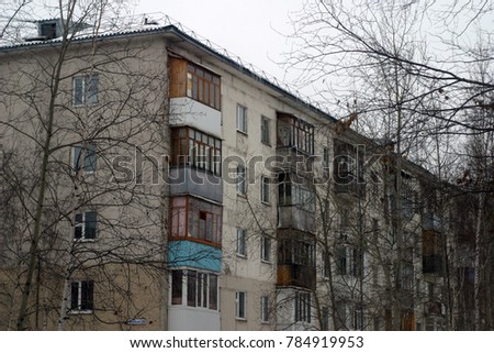 Bare branches against the background of an apartment house. Autumn and winter background