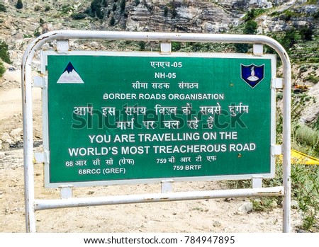 Public Sign Board saying - YOU ARE TRAVELLING ON THE WORLD'S TREACHEROUS ROAD. The place roads are in Spiti Valley, Himachal Pradesh, India.