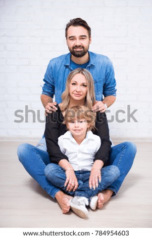family portrait - parents and little son over white brick wall