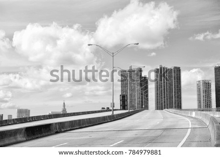 miami highway or public road roadway for transport vehicles and urban skyscrapers on cloudy blue sky background next to the port, miami dade