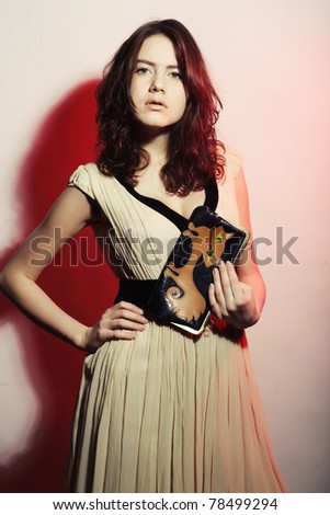 Fashion photo, model with a bag posing on light background