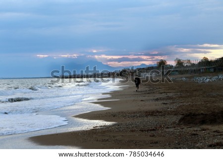 A woman is walking at  Lara Beach at sunset time in Antalya