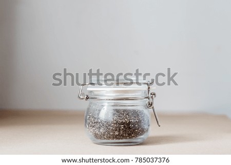 Chia seeds in glass jar on table with space for text, daylight