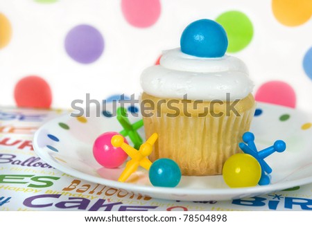 gumballs and toy jacks with cupcake