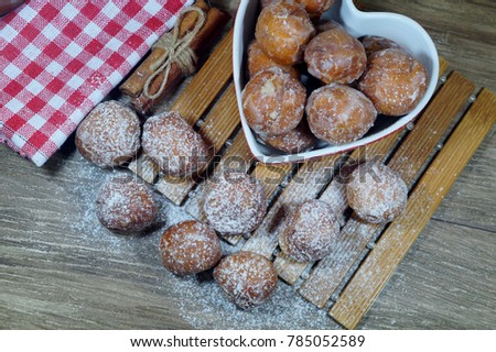 Sweet small donuts in the platter in the shape of a heart. . The fat Thursday of carnival. Slavic tradition