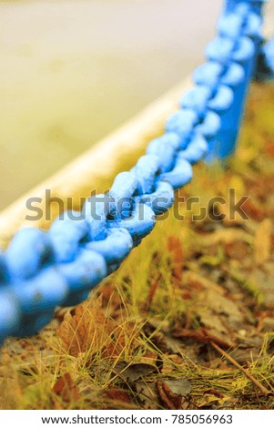 A large old blue chain of rusty metal in the city.