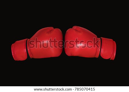 Red Boxing gloves isolated on black background. Two Boxing gloves to each other.