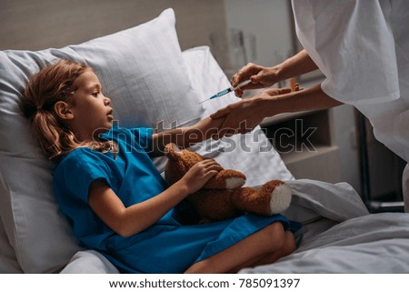 cropped image of female doctor making vaccination to scared kid 