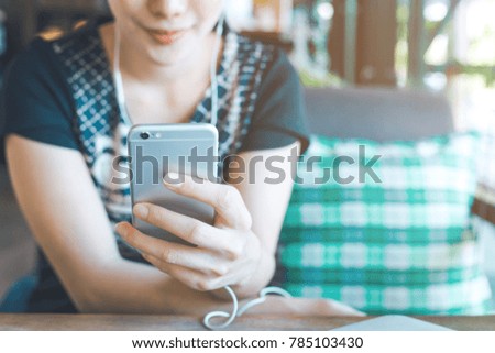 Women hand are listening to music from mobile phones.