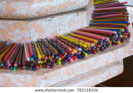Candles of various colors lying in Magellan's cross. Cebu, Philippines.