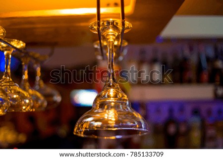 different glasses hanging over the bar. Soft focus