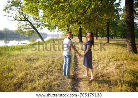 Loving couple holding hands and walking outdoors on a sunny day