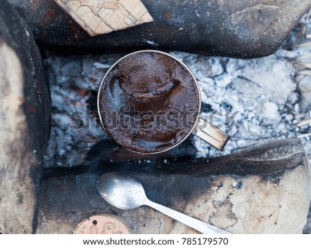 Preparation of natural coffee on fire. Photo for the desktop. In an iron mug.